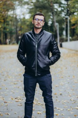 Deri ceketli gözlüklü bir adam.