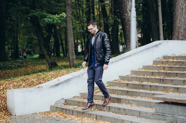 Stock image a man in a leather jacket comes down the stairs