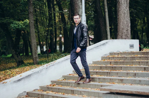 stock image a man in a leather jacket comes down the stairs