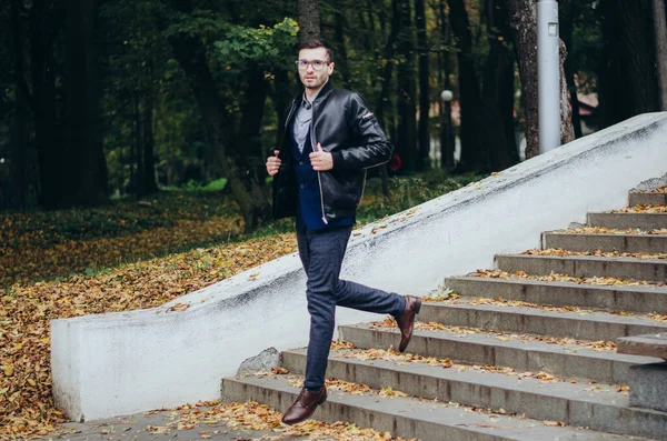 stock image a man in a leather jacket comes down the stairs