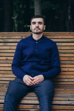 Bir adam parkta bankta oturuyor.