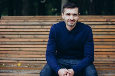 Bir adam parkta bankta oturuyor.