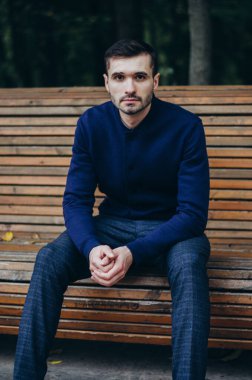 Bir adam parkta bankta oturuyor.