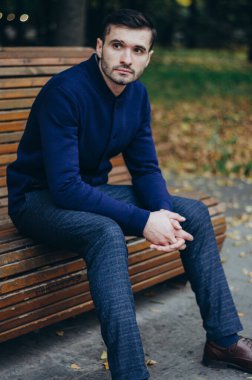 Bir adam parkta bankta oturuyor.