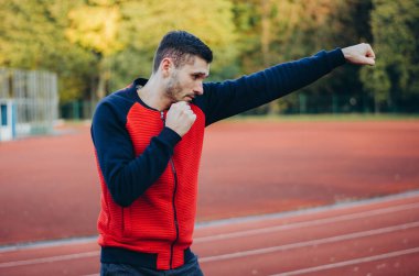 a man in a sweatshirt boxing alone