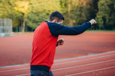 a man in a sweatshirt boxing alone