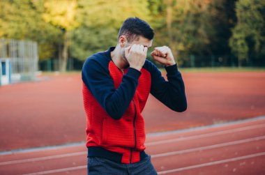 a man in a sweatshirt boxing alone