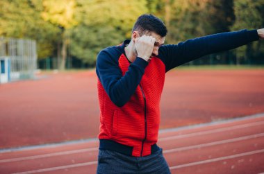 a man in a sweatshirt boxing alone