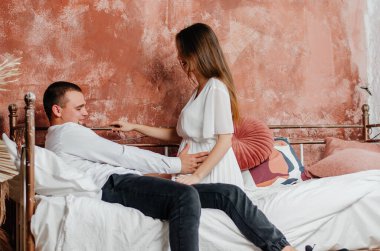 pregnant woman with man in bed