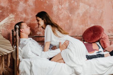 pregnant woman with man in bed