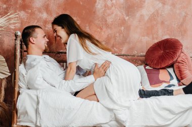 a woman and a man are hugging in bed