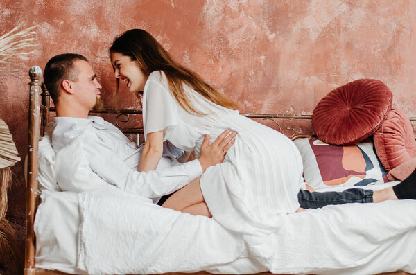 a woman and a man are hugging in bed