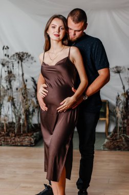 a young man hugs a pregnant woman
