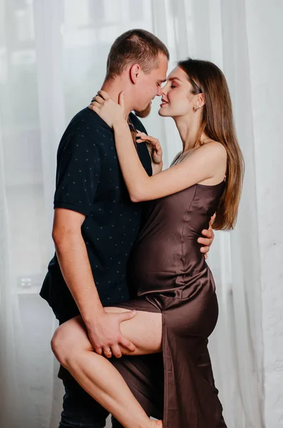 Stock image a young man hugs a pregnant woman