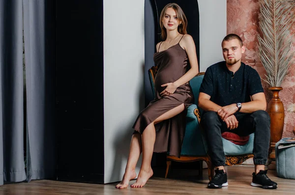 stock image a pregnant woman and a man are sitting in a chair