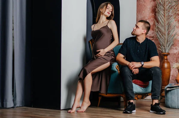 stock image a pregnant woman and a man are sitting in a chair