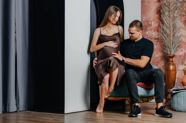 Eine Schwangere Frau Sitzt Mit Einem Mann Auf Einem Sessel — Stockfoto