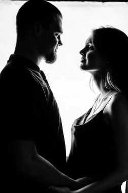 Beyaz arka planda birbirine bakan bir çift. Siyah beyaz fotoğraf