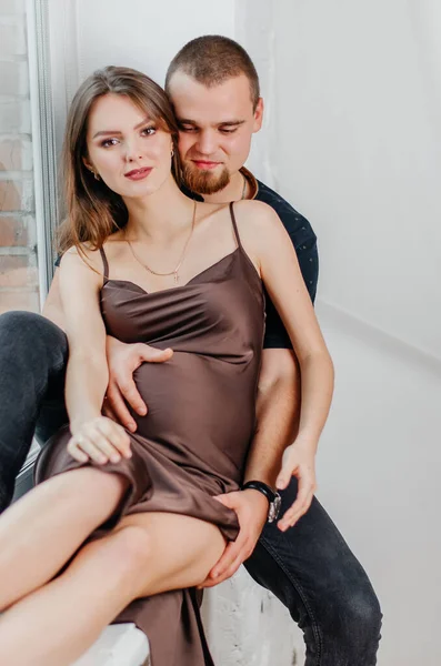 Hombre Una Mujer Embarazada Están Sentados Alféizar Ventana Abrazándose —  Fotos de Stock