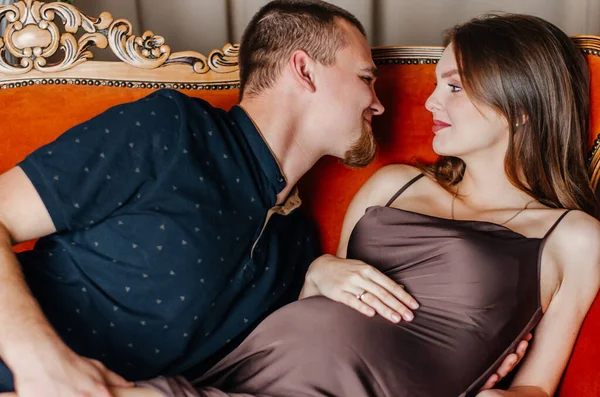 妊娠中の女性が夫とソファに横になっている — ストック写真