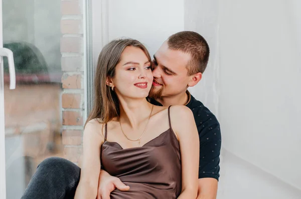 Hombre Una Mujer Embarazada Están Sentados Alféizar Ventana Abrazándose —  Fotos de Stock