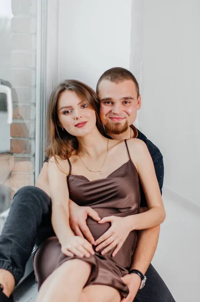 Ein Mann Und Eine Schwangere Frau Sitzen Auf Einer Fensterbank — Stockfoto