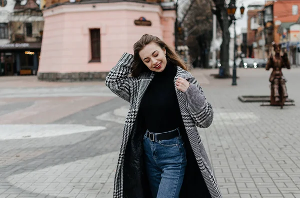 stock image Woman walking on the street in a coat