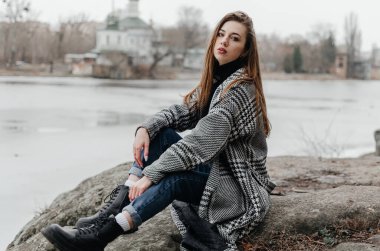 Nehrin kıyısındaki bir kayanın üzerinde oturan bir kız