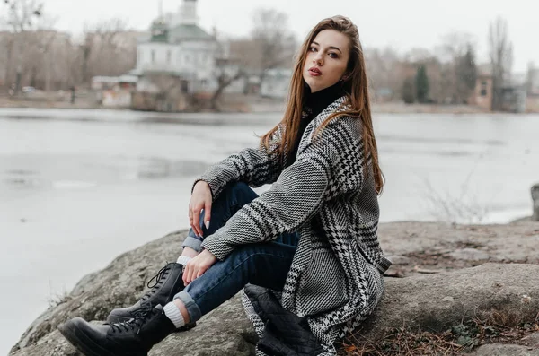 Nehrin kıyısındaki bir kayanın üzerinde oturan bir kız