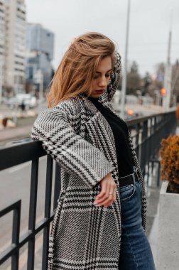 Kız korkuluklara yaslanıyor.