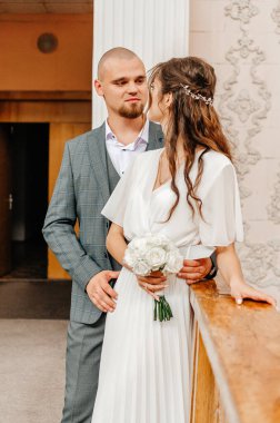 Gelin ve damat korkuluklarda sarılıyorlar.