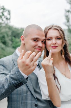 Gelinler parmaklarında alyans gösteriyor.