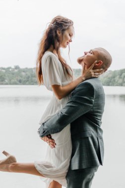 damat gelini kollarında tutar.