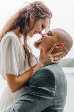 Gelin ve damat sarılıyor ve gülümsüyor.