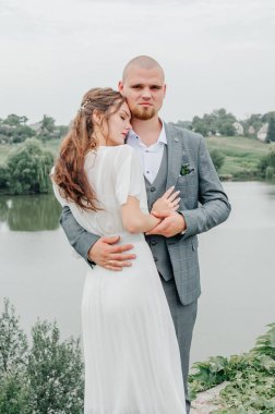 Gelin ve damat gölün arka planında kucaklaşıyor.