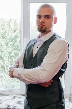 Pencerenin yanındaki damadın portresi.