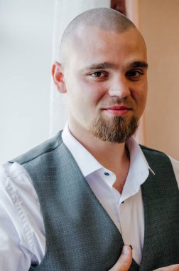 Pencerenin yanındaki damadın portresi.