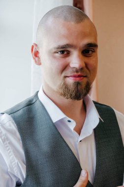 Pencerenin yanındaki damadın portresi.