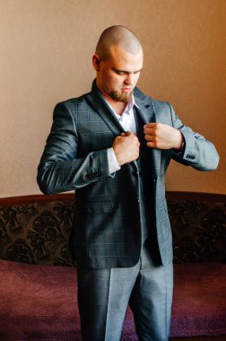 Damat bir ceket giyer.