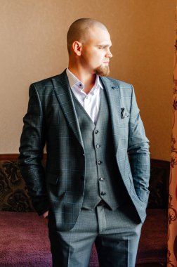 Takım elbiseli damat başka tarafa bakıyor.