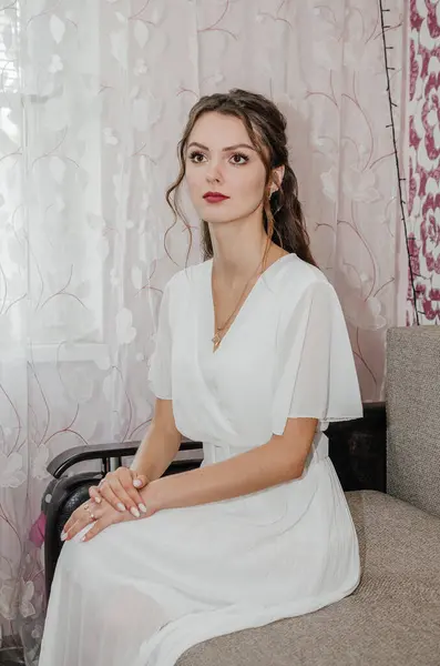 stock image the bride in a wedding dress is sitting on the couch