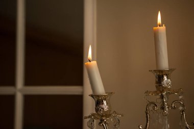 Üzerinde beyaz mumlar olan gümüş renkli bir şamdan.
