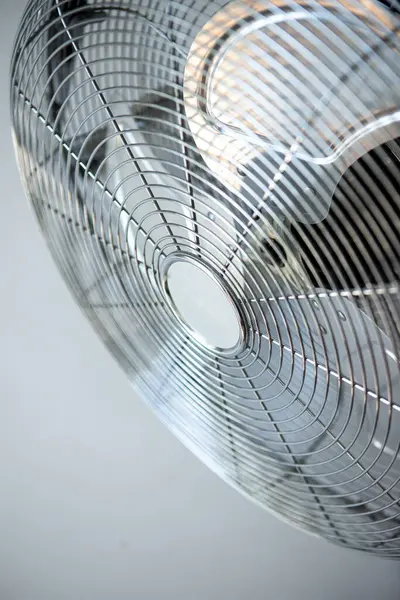 Stock image a fan with a black cord on it sits on a white surface