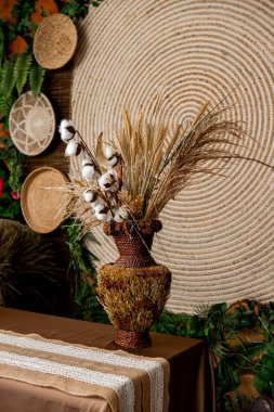 Vazoda buğday ve diğer bitkilerle süslenmiş süsler ve nakışlı süsler.