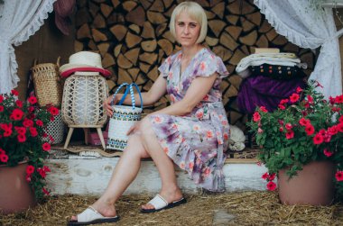 Woman sitting in rustic decor with wicker and flowers clipart