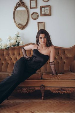 Vintage Sofa 'da uzanan zarif kadın.