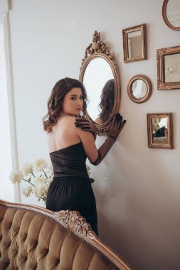 Samimi bir odada kaliteli bir ayna tutan zarif bir bayan.