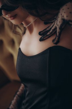 Siyah korseli ve dantel eldivenli bir kadın dekoltesi.