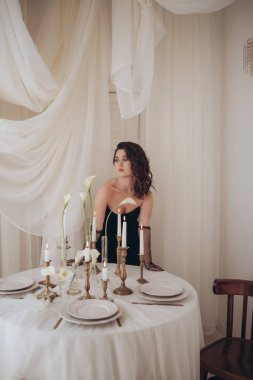 Şenlik masasında, içi aydınlık mumlarla dolu zarif bir kadın.