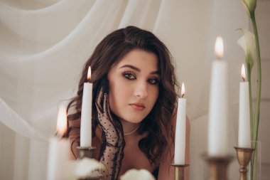 Dramatik mum ışığında bir kadının moda portresi